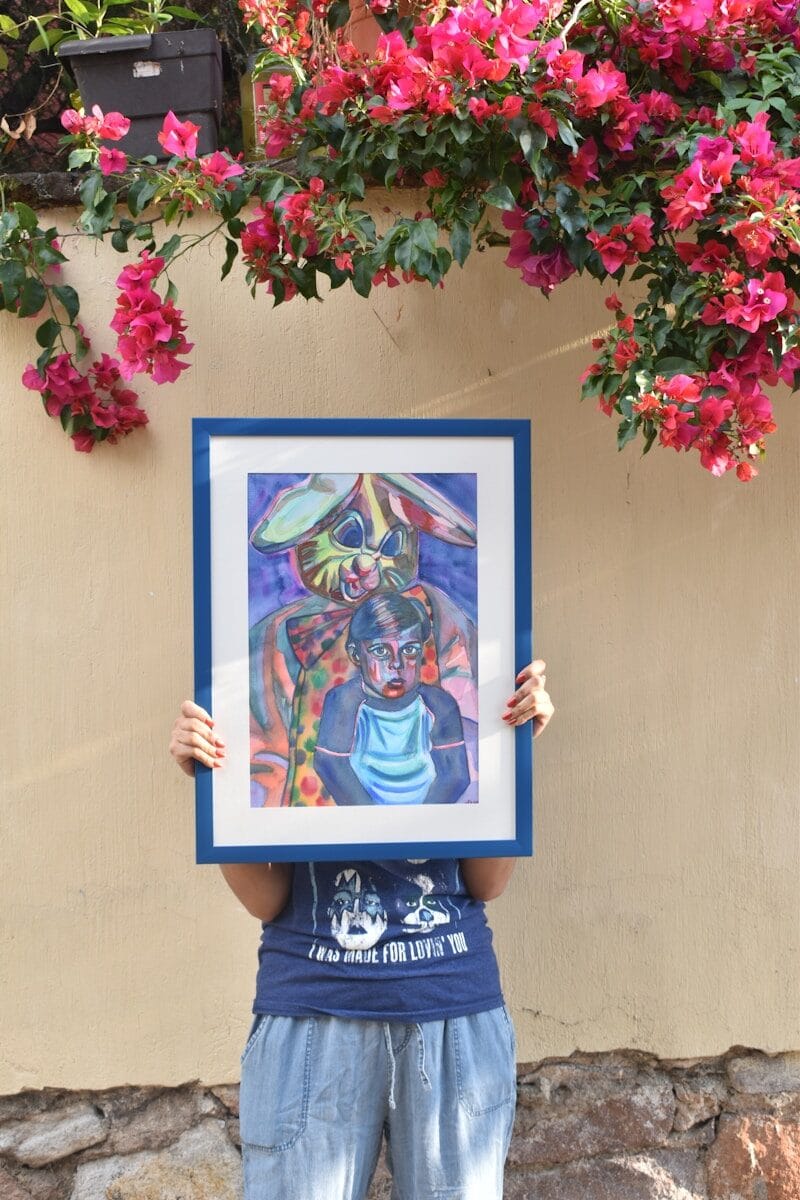 Person holding artwork with colorful figures